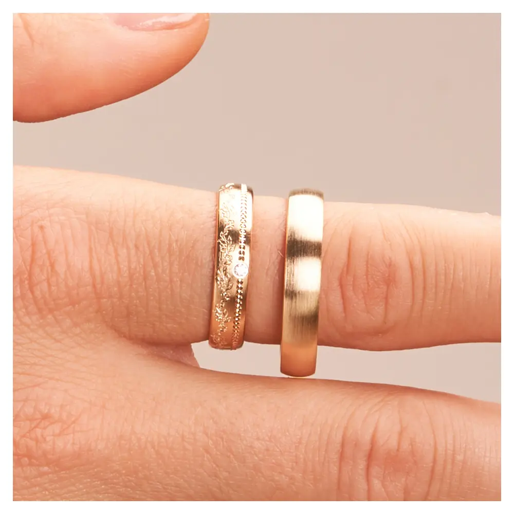 Matte Sommergold Eheringe mit Diamanten und blumigem Muster im Damenring auf Finger