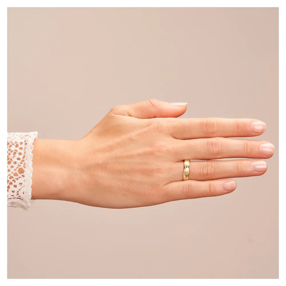 Mattierter Ehering aus Gelbgold mit Diamanten und Blumenmuster auf Hand