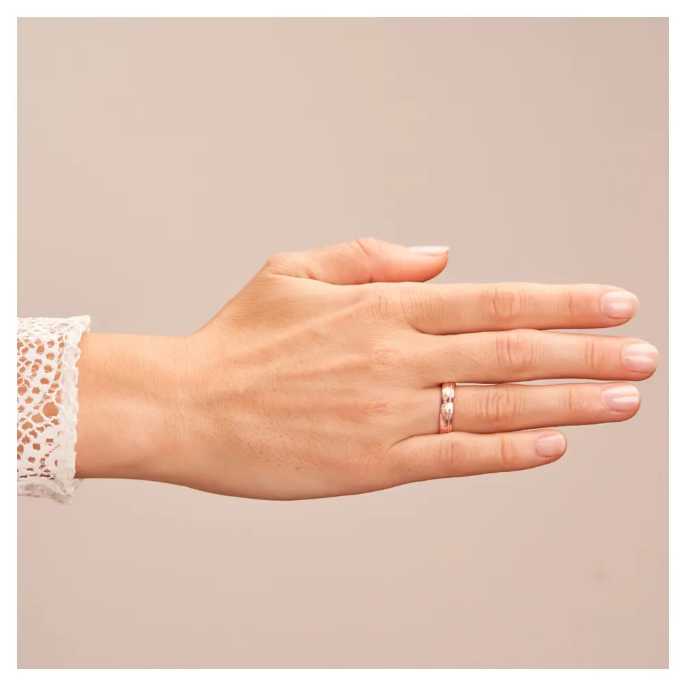 Roségold Ehering mit Diamanten und blumigem Muster auf Hand