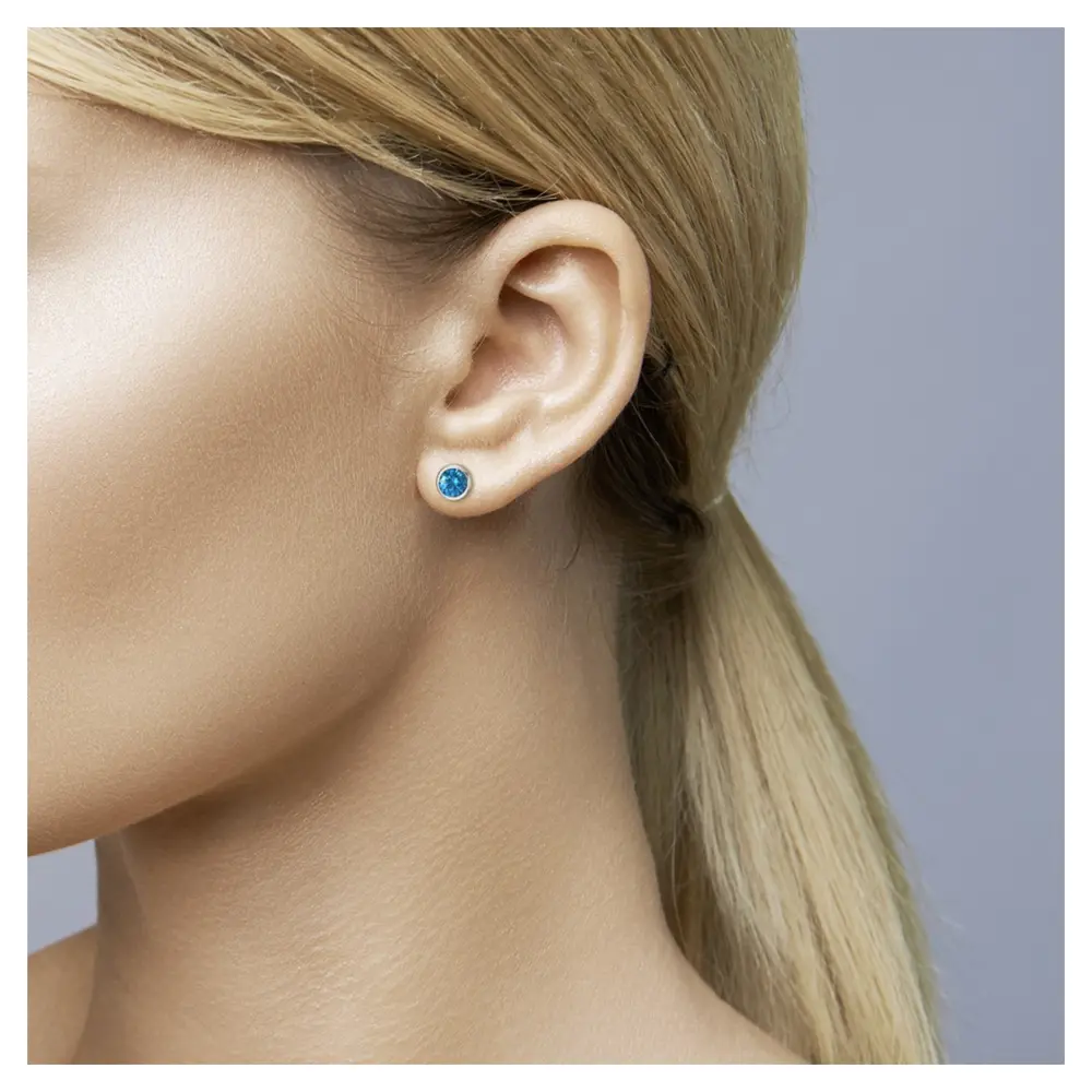 Edelstahl Ohrstecker mit blauen Zirkonia im Ohr