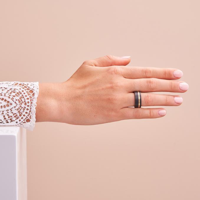 Aufnahme von Partnerringen aus gemasertem Carbon mit Gelbgold Seitenstreifen auf Hand