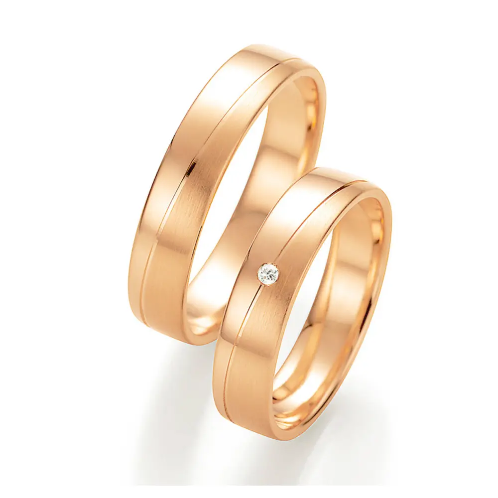 Trauringe aus Roségold mit schräg verlaufender Rille und Diamanten