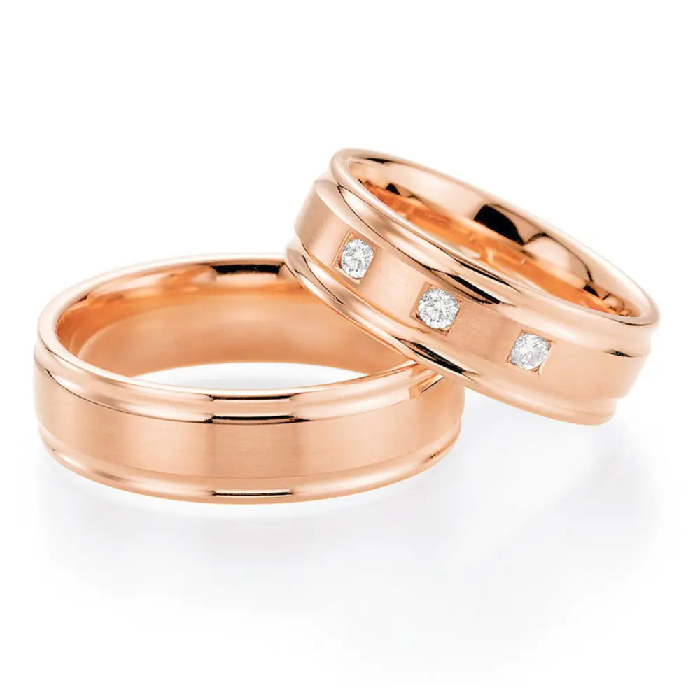 Rotgold Trauringe mit drei Diamanten in viereckigen Vertiefungen