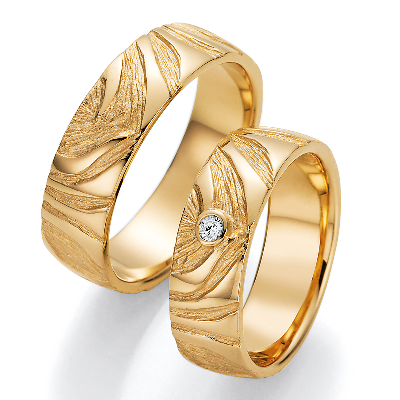 Aufnahme der Eheringe aus Gelbgold mit Rillen in Holzoptik und Diamanten
