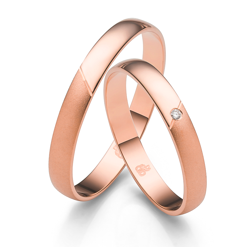 Aufnahme der Eheringe in Roségold mit glänzender und sandmattierter Flächen mit Diamanten
