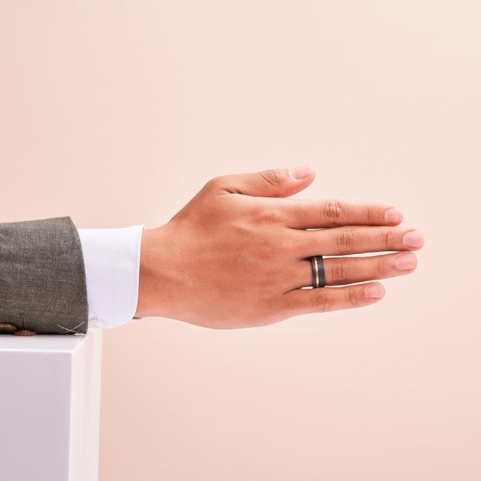 Aufnahme von Partnerringen aus gemasertem Carbon mit Gelbgold Seitenstreifen auf Hand