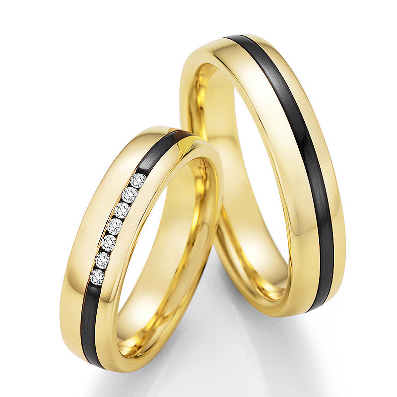 Aufnahme von Trauringen aus Gelbgold & Zirconium bicolor längsmattiert mit sieben weißen Diamanten 