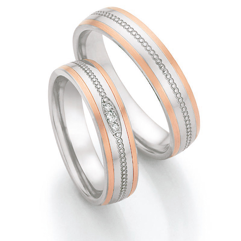 Aufnahme von Eheringen aus Edelstahl mit Roségoldrändern und drei Diamanten