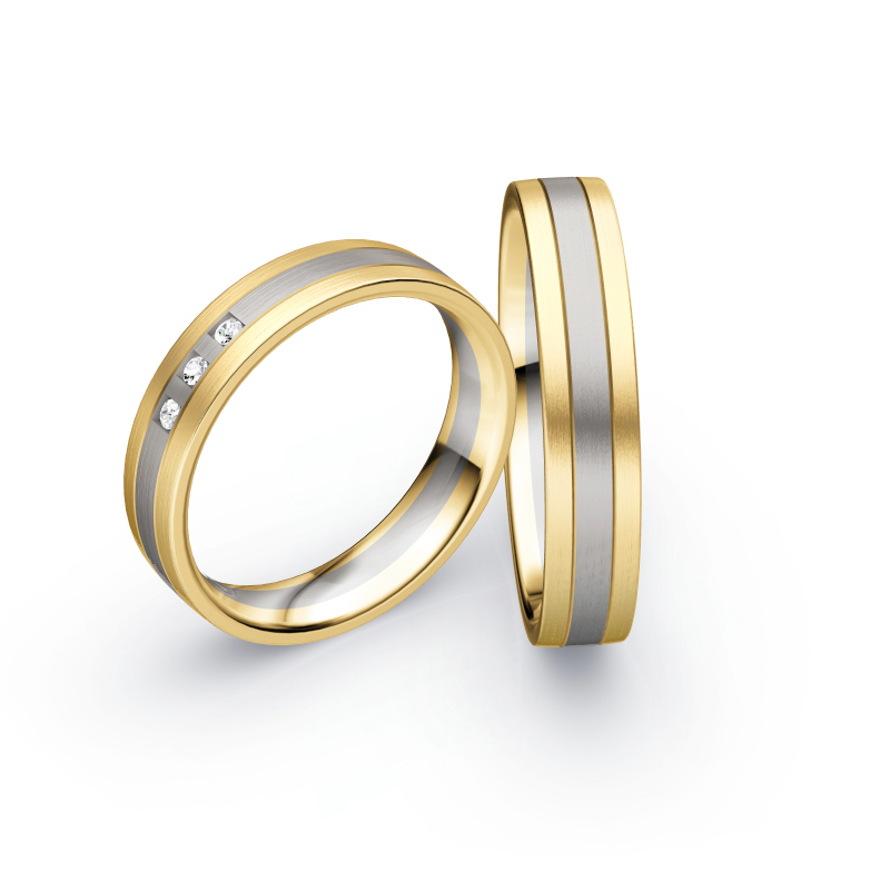 Aufnahme von Trauringen in Gelbgold und Palladium 500 längsmatt mit drei weißen Diamanten 