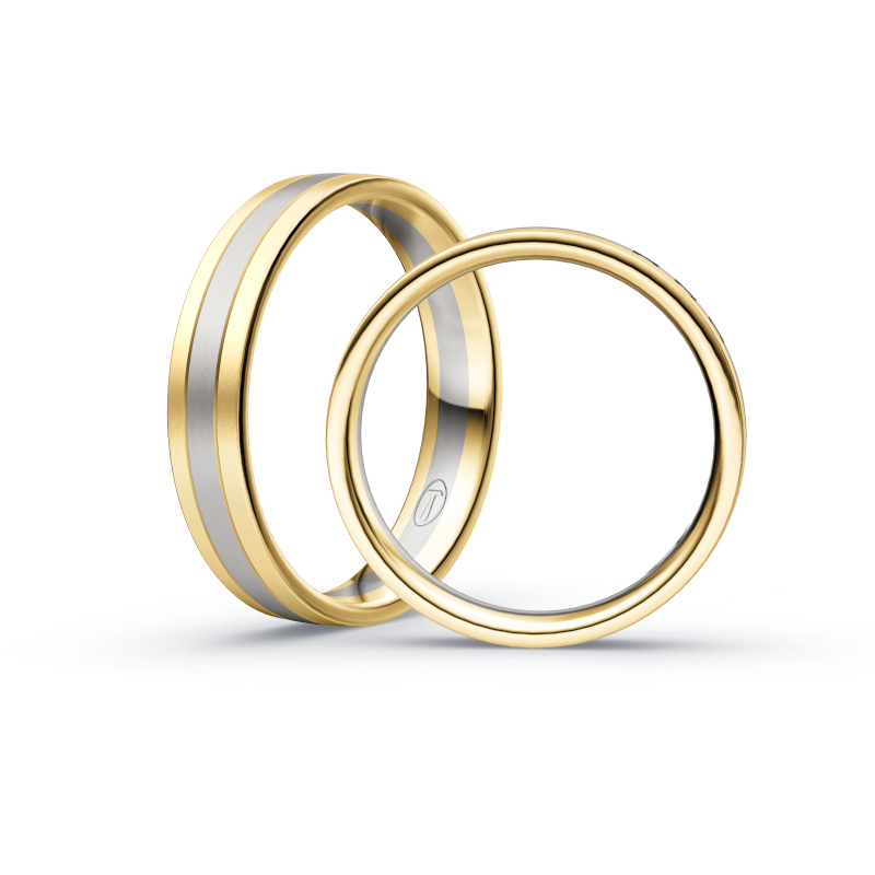 Aufnahme von Trauringen in Gelbgold und Palladium 500 längsmatt mit drei weißen Diamanten 