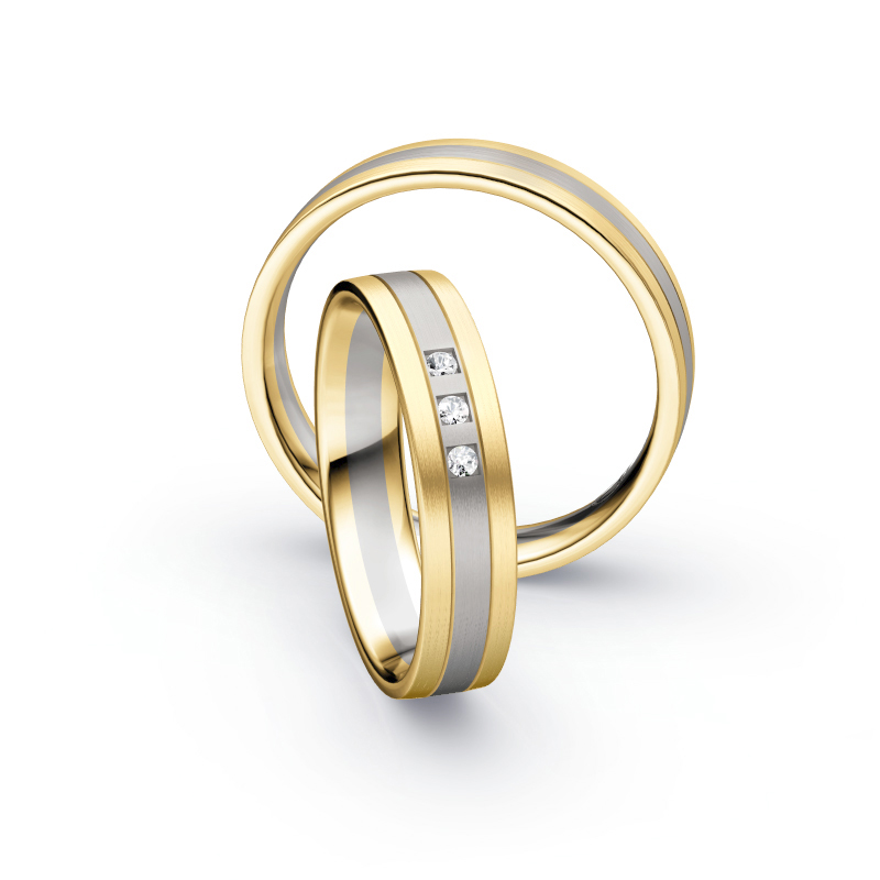 Aufnahme von Trauringen in Gelbgold und Palladium 500 längsmatt mit drei weißen Diamanten 