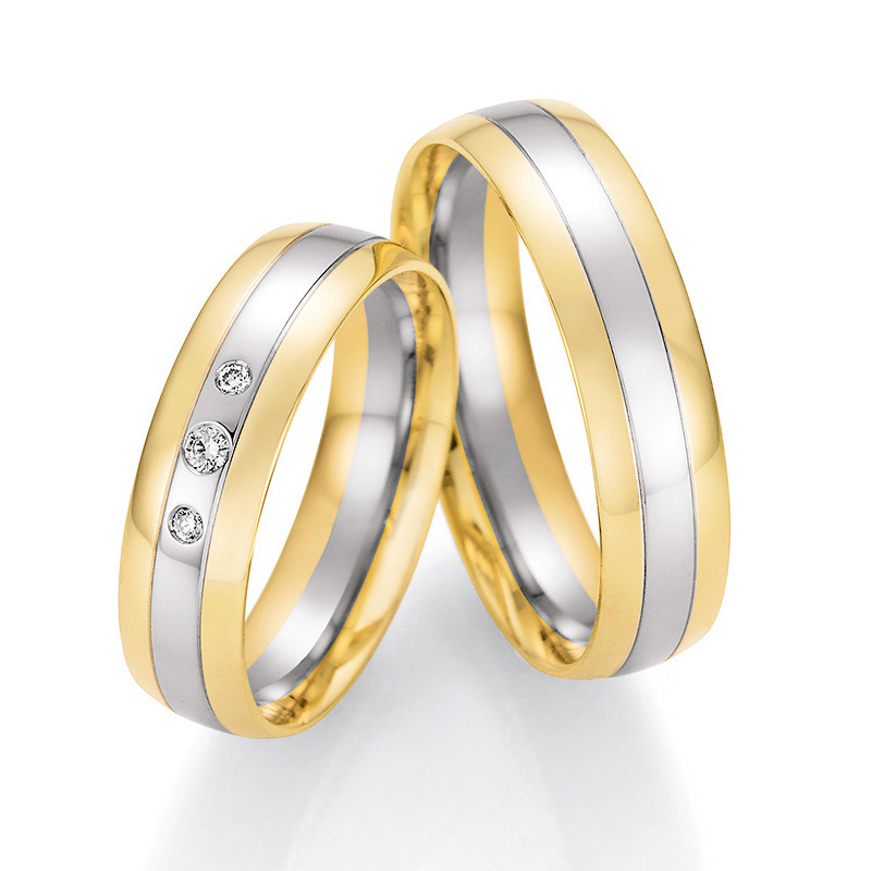 Aufnahme von Trauringen aus Palladium 500 & Gelbgold bicolor mit drei runden Diamanten