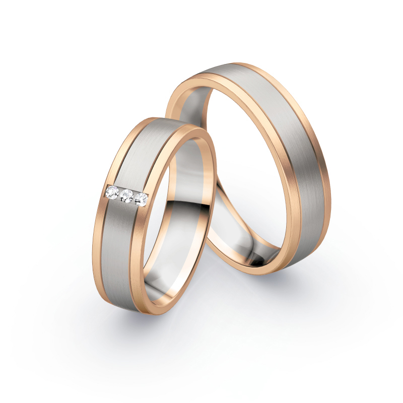Aufnahme von Trauringen aus Palladium 500/Rosègold längsmattiert mit drei mittig gesetzten Diamanten