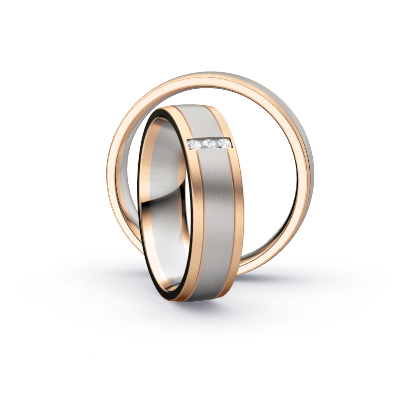 Aufnahme von Trauringen aus Palladium 500/Rosègold längsmattiert mit drei mittig gesetzten Diamanten