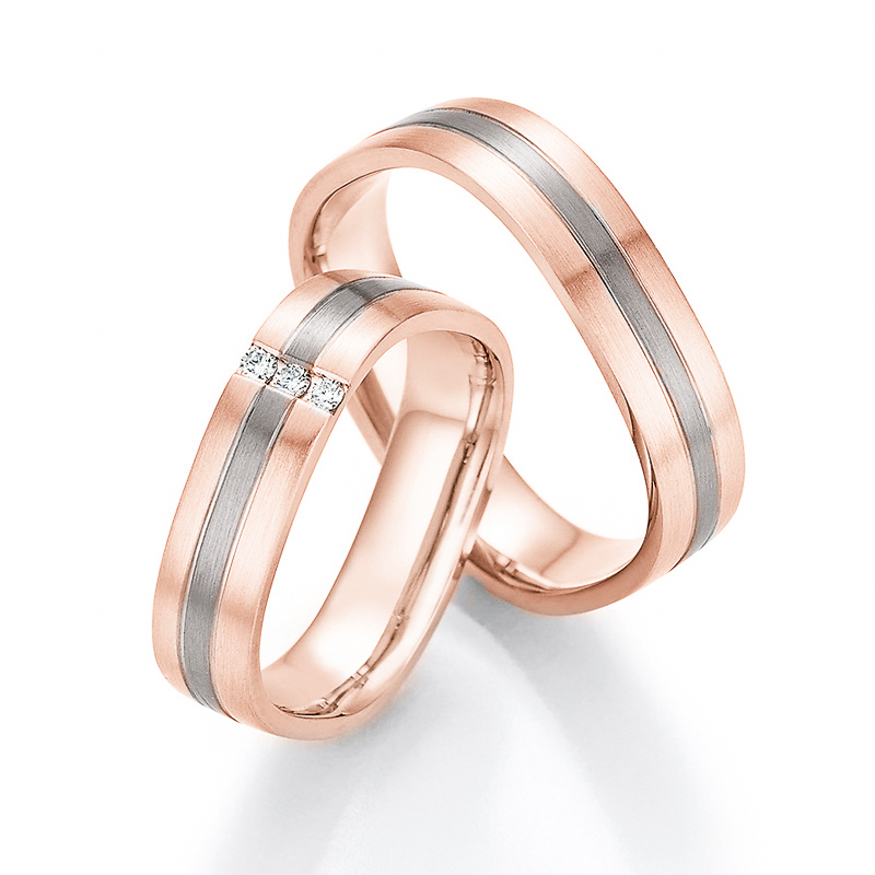 Aufnahme von Trauringen aus Rosègold/Palladium 500 mit seitlich gesetzten weißen Diamanten 
