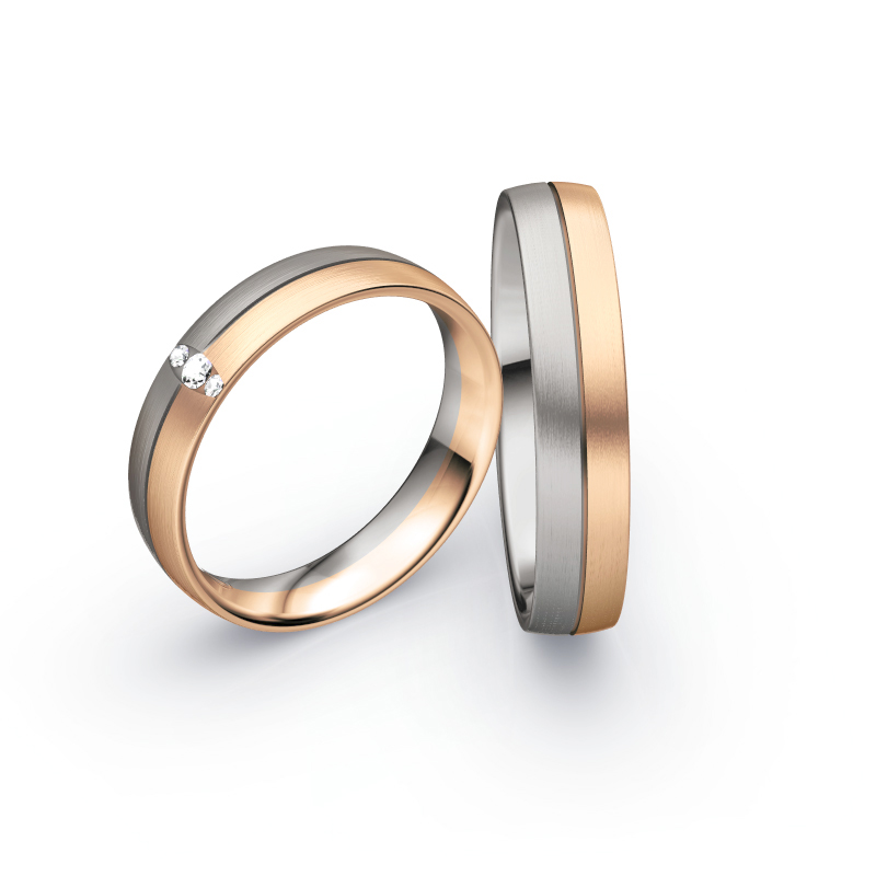 Aufnahme von Trauringen in Palladium 500 und Roségold längsmatt mit drei Diamanten in ovaler Fassung