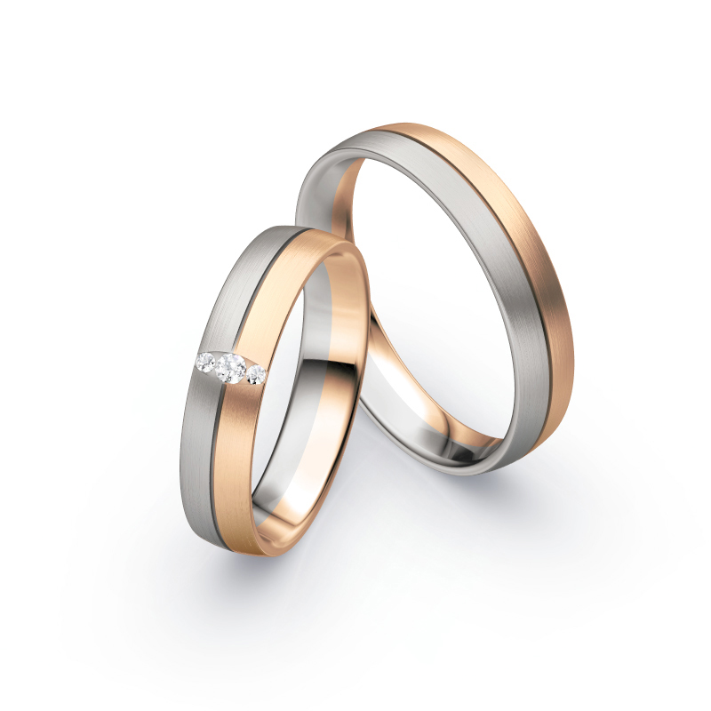 Aufnahme von Trauringen in Palladium 500 und Roségold längsmatt mit drei Diamanten in ovaler Fassung