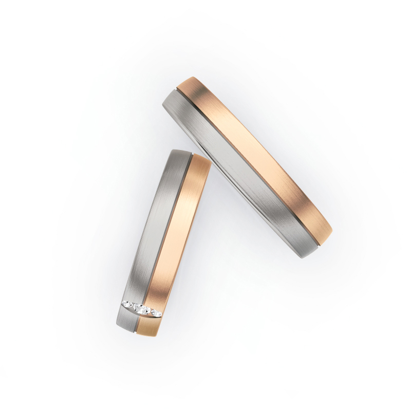 Aufnahme von Trauringen in Palladium 500 und Roségold längsmatt mit drei Diamanten in ovaler Fassung