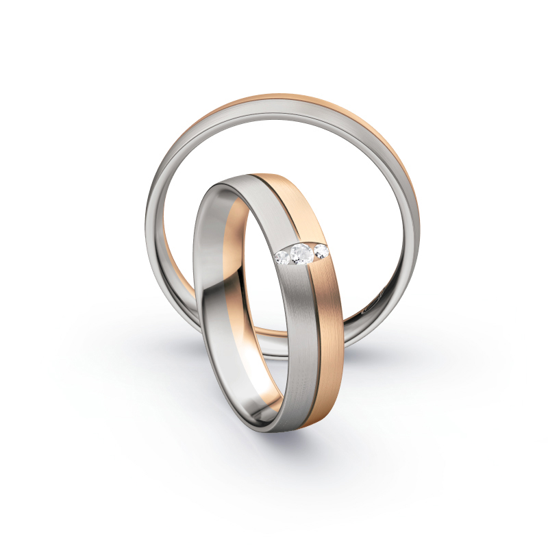 Aufnahme von Trauringen in Palladium 500 und Roségold längsmatt mit drei Diamanten in ovaler Fassung