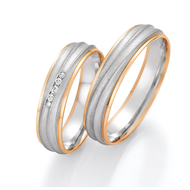 Aufnahme Trauringen aus Palladium 500/Rosègold sandmatt mit fünf Diamanten