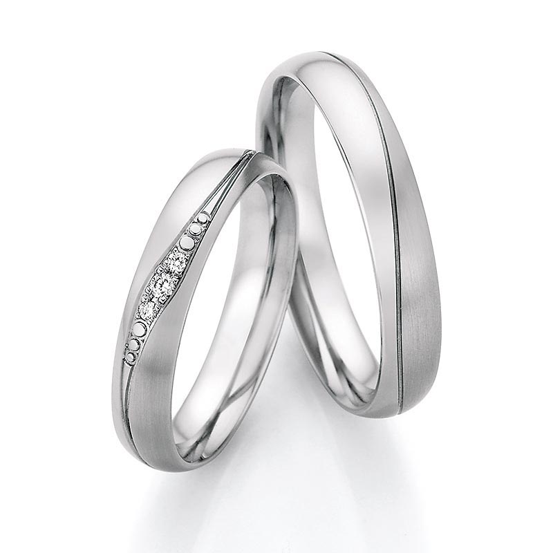 Aufnahme von Trauringen aus Edelstahl mit drei Diamanten in elegant verlaufender Rille