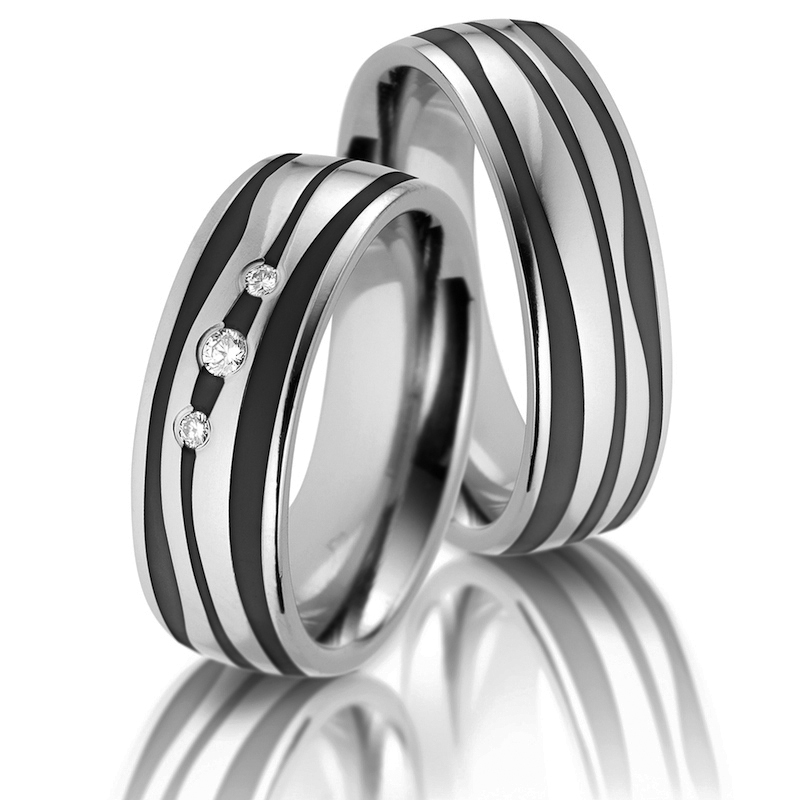 Aufnahme von Trauringen aus Titan und Keramik mit schwarz-weißen Wellen und 3 Diamanten 