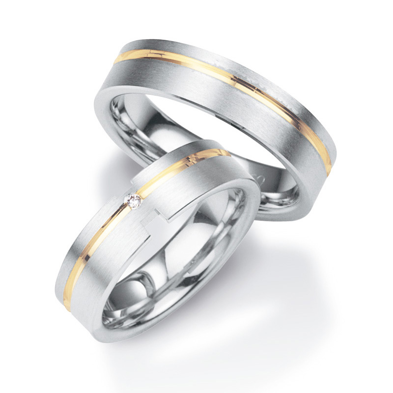 Aufnahme von Trauringen aus platiniertem Silber veredelt mit Gelbgold mit Rillen und Diamanten   