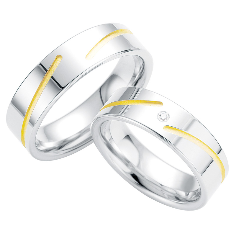 Aufnahme von Trauringen aus Silber mit elegant verlaufender gelbgoldfarbiger Rille und Diamanten