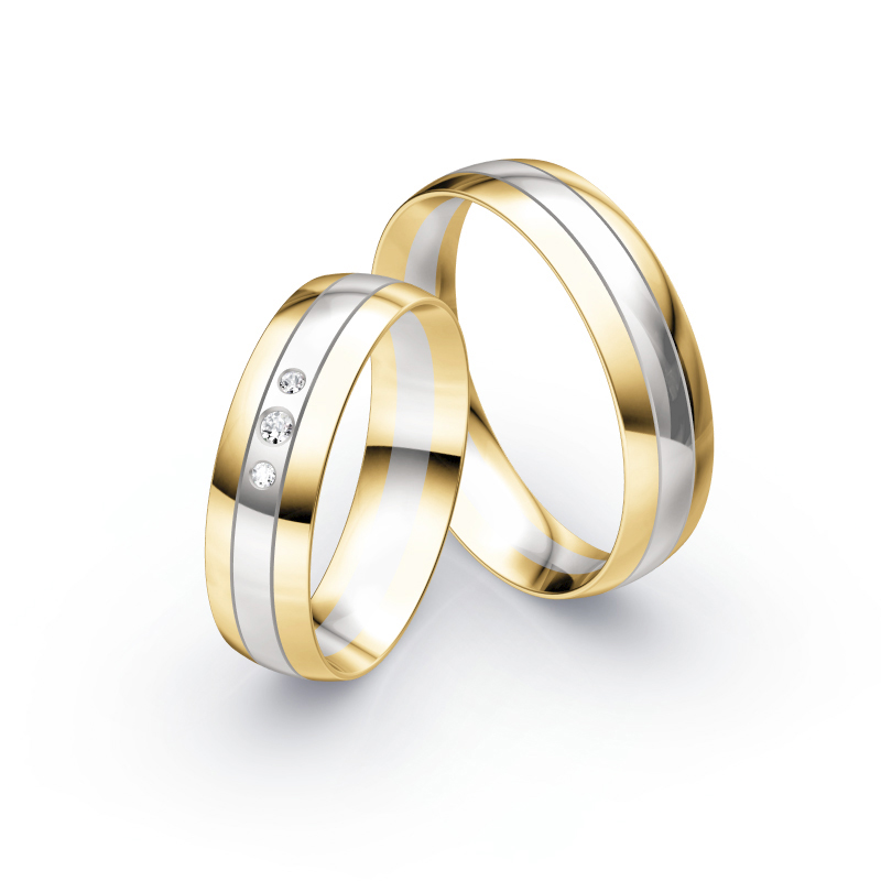 Aufnahme von Trauringen aus Weißgold mit Gelbgoldrändern und mittigen Diamanten