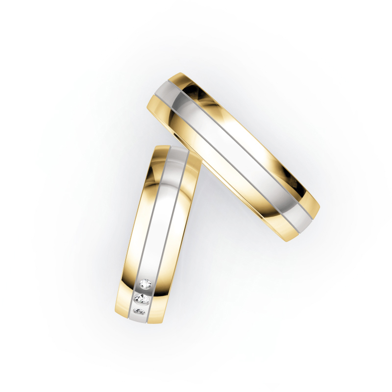 Aufnahme von Trauringen aus Weißgold mit Gelbgoldrändern und mittigen Diamanten