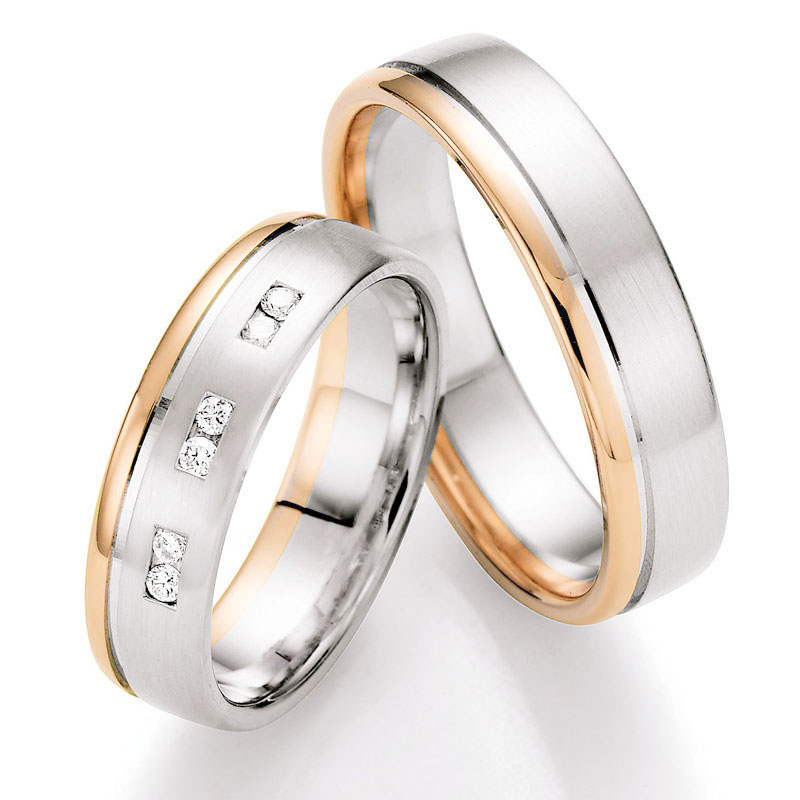 Aufnahme von Trauringen in Rotgold/Weißgold mit polierter Rille und sechs weißen Diamanten