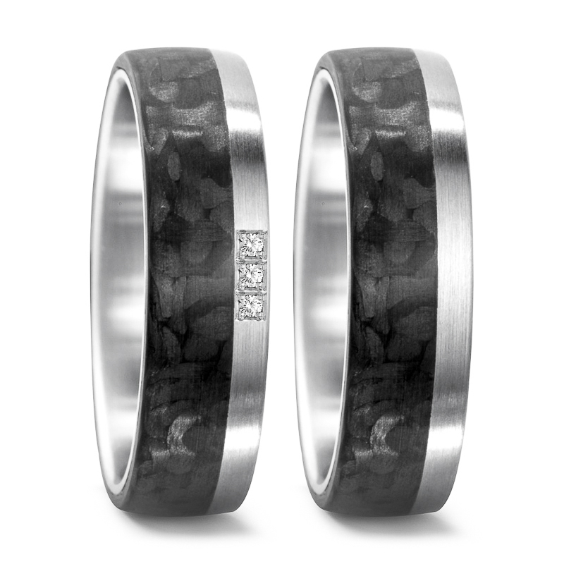 Aufnahme der Trauringe aus Carbon und Stahl mit hellem Rand und 3 Diamanten