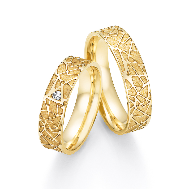 Aufnahme der Gelbgold Trauinge mit sandmattem geometrischem Muster und Diamanten in Dreieck