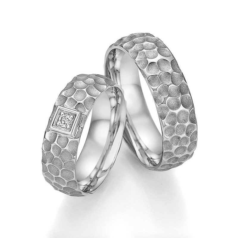 Aufnahme der Trauringe aus Platin mit mattem Muster und Diamanten in Quadrat