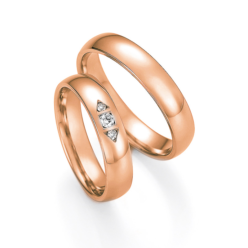 Aufnahme der Trauringe in Rotgold mit 3 Diamanten in pfeilförmig gefassten Vertiefungen