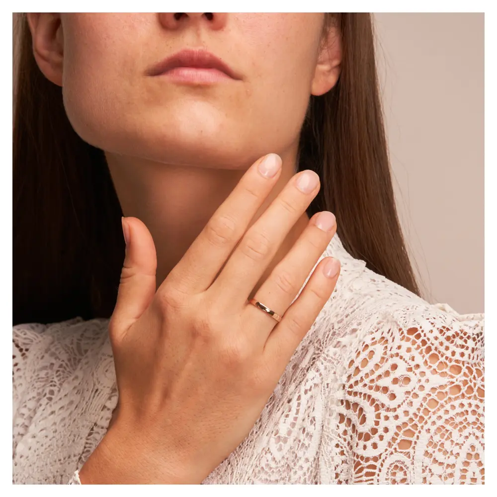 Trauringe aus Rosegold mit 2,5 mm Breite poliert auf Hand am Gesicht