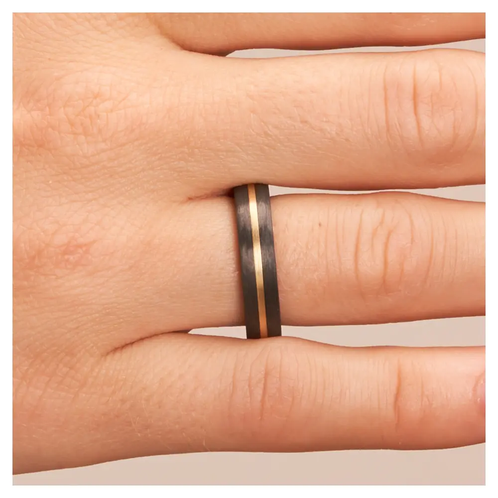 Eheringe aus Carbon mit Gelbgoldstreifen auf Hand im Zoom