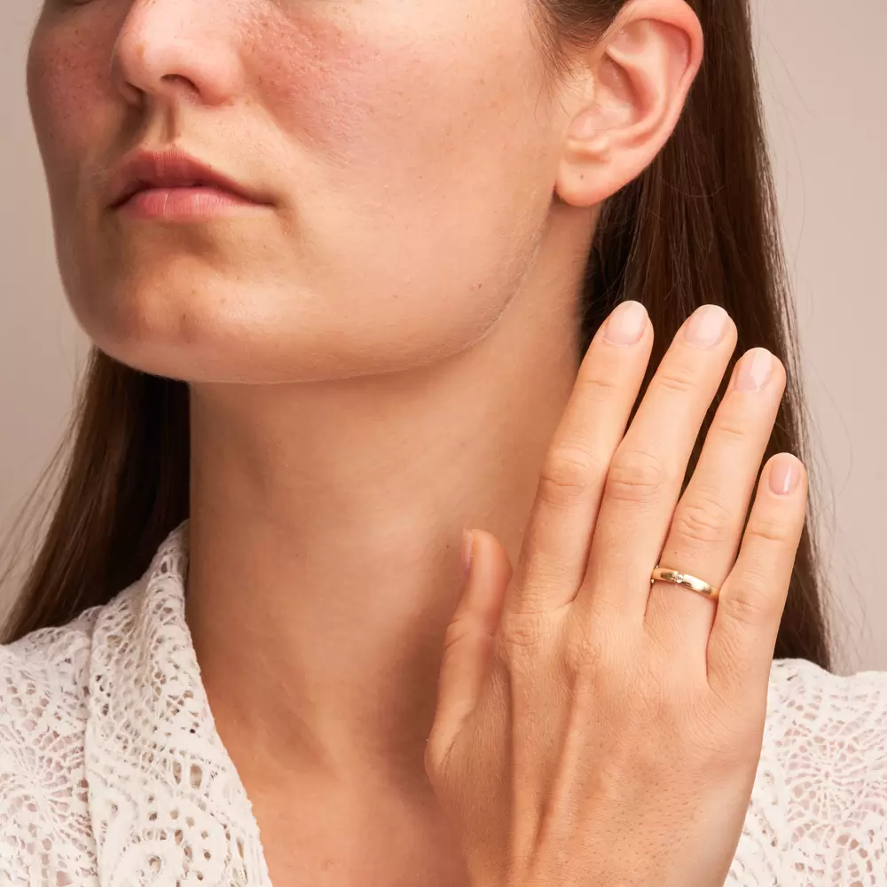 Gelbgold Eheringe mit 0,04 Karat Diamanten und längsmatter Oberfläche auf Hand