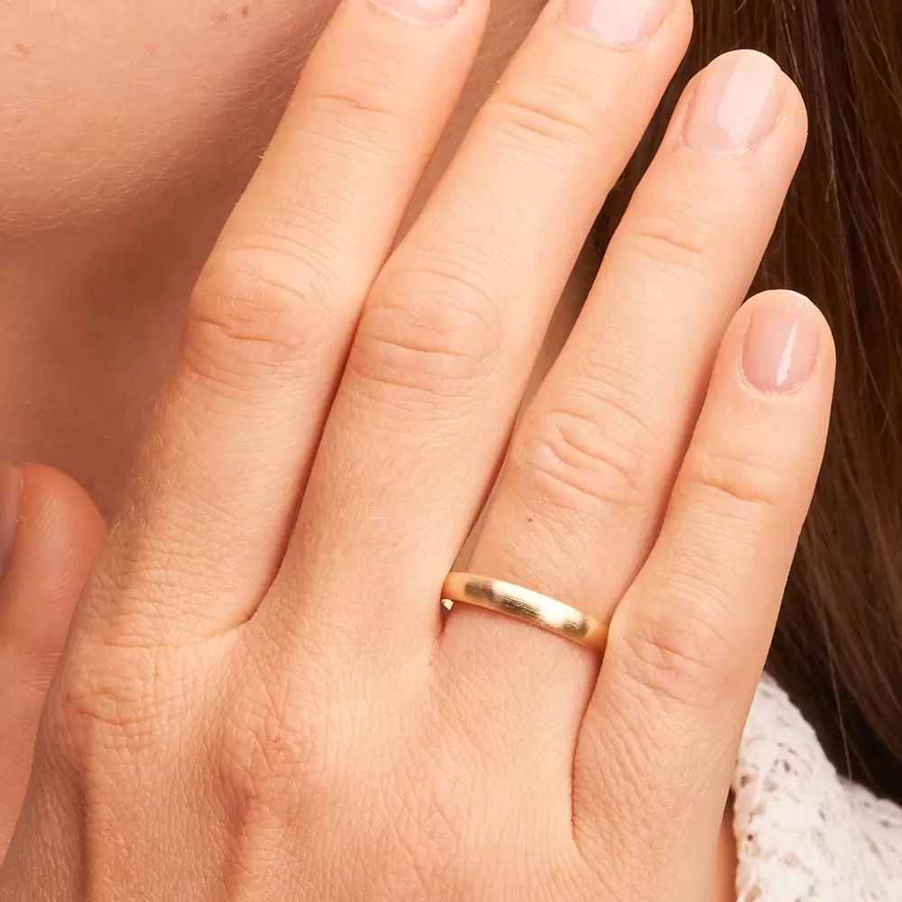 Gelbgold Eheringe mit längsmatter Oberfläche auf Hand im Zoom