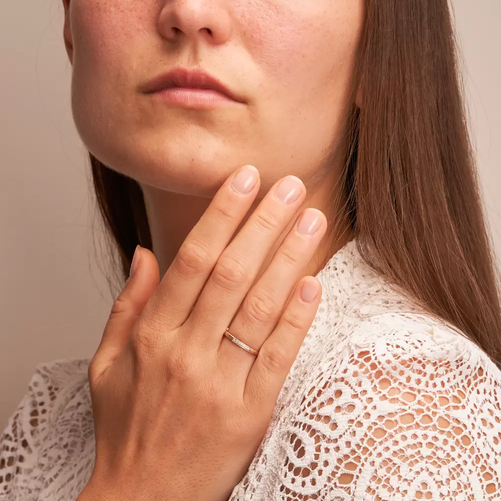 Schmaler Ehering aus Herbstgold in Quermattierung mit 7 Diamanten auf Hand