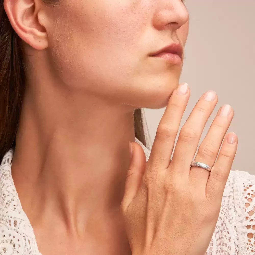 Eheringe aus strukturiertem Weißgold mit 0,04 Karat Diamanten auf Hand