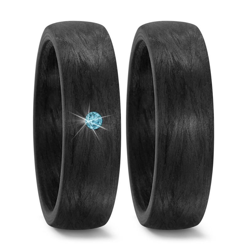 Aufnahme von gemaserten Eheringen aus Carbon mit blauem mittigem Diamanten