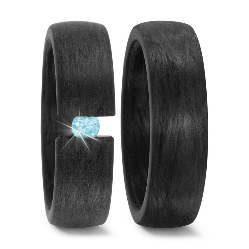 Aufnahme von schwarzen gemaserten Carbon Eheringen mit eingespanntem blauen Diamanten 