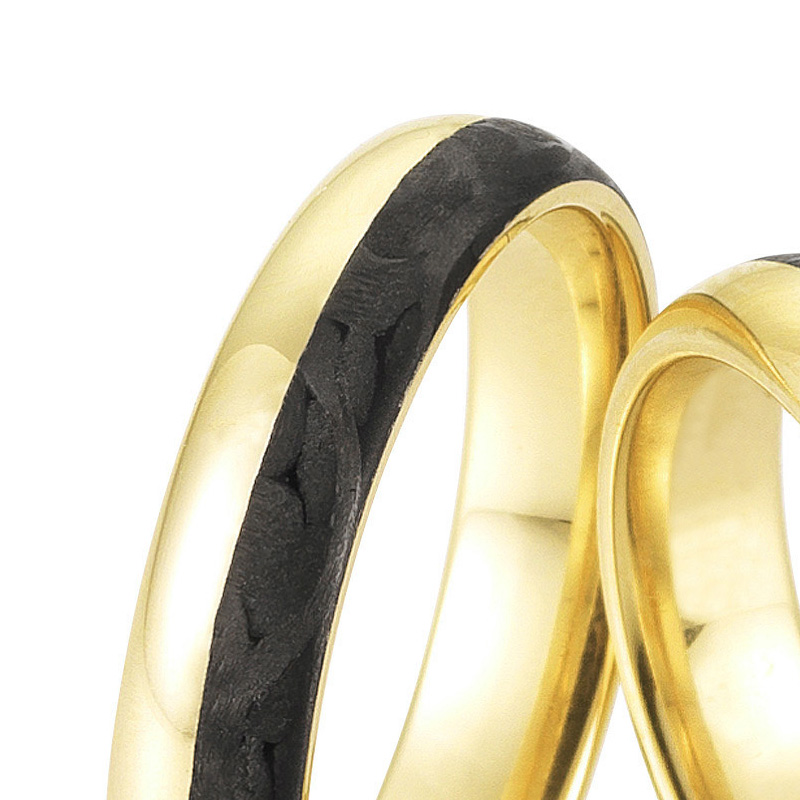 Aufnahme von Eheringen aus poliertem Gelbgold mit Carbonstreifen und 9 Diamanten