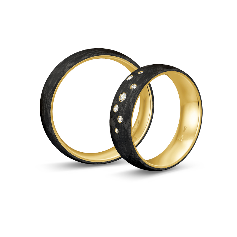 Aufnahme von gemaserten Eheringen aus Gelbgold&Carbon mit Diamanten in Sternenhimmel-Optik