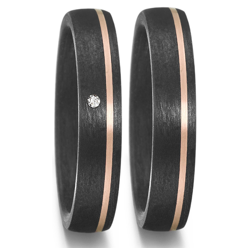 Aufnahme von Trauringen aus Carbon mit schmalem Roségoldstreifen und weißem Diamanten