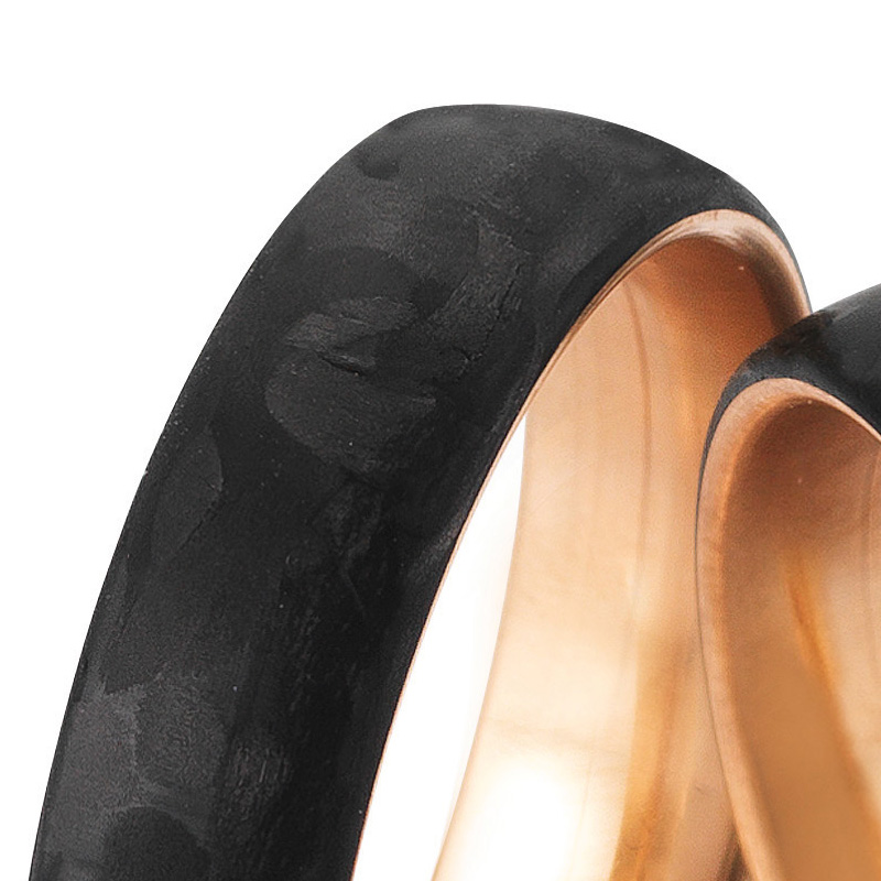 Aufnahme von gemaserten Eheringen aus Rotgold&Carbon mit Diamanten in Sternenhimmel-Optik