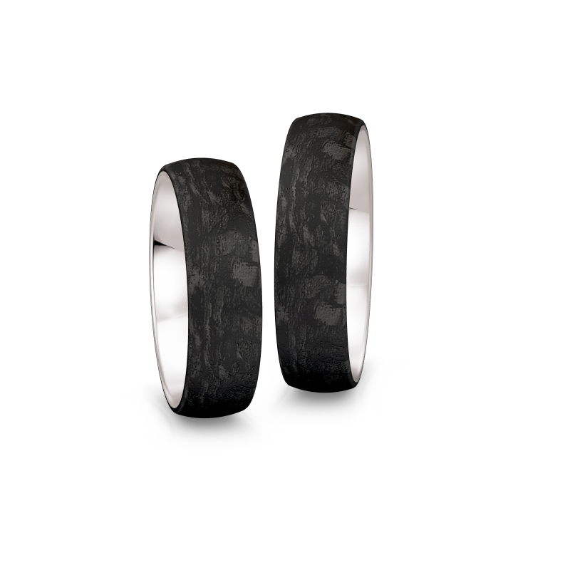 Aufnahme von gemaserten Eheringen aus Weißgold&Carbon mit Diamanten in Sternenhimmel-Optik