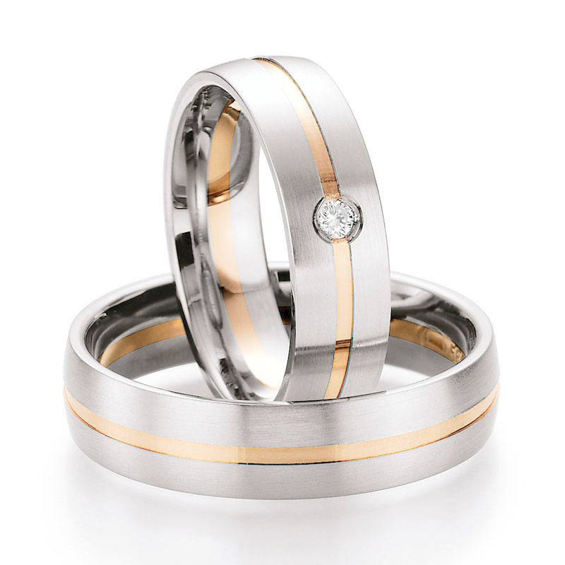 Aufnahme von Trauringen in Weißgold & Rotgold mit Rille rundem mittigem Diamanten 