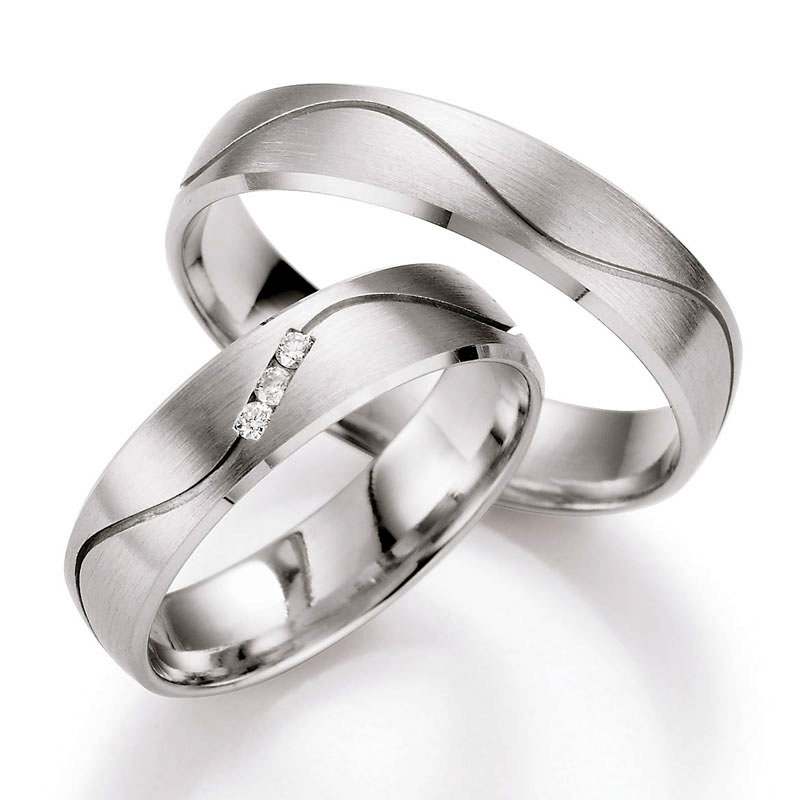 ufnahme von Palladium 500 Trauringen mit Rille und drei originell gesetzten Diamanten